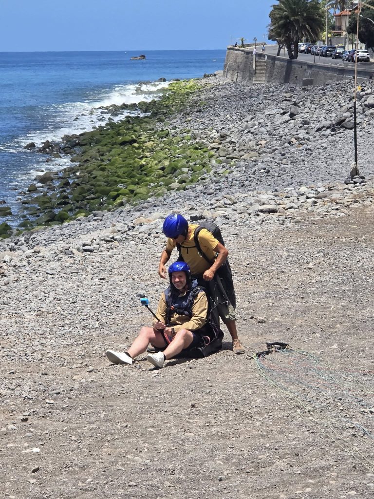 Paragliding-landing van Rinaldo op het strand van Madeira met blauwe lucht op de achtergrond