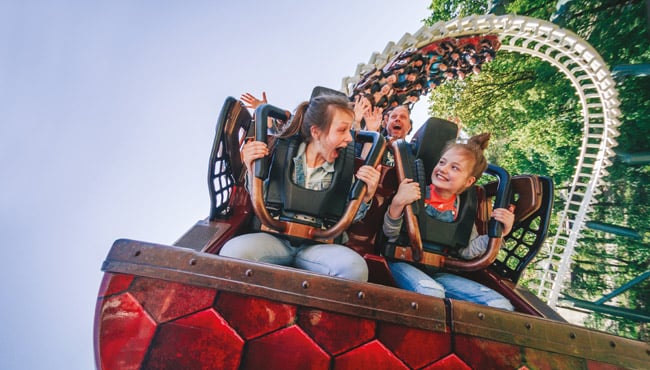 Mensen gillen in een achtbaan met looping – symbool voor de onverwachte wendingen van het leven en de emoties die daarbij horen.