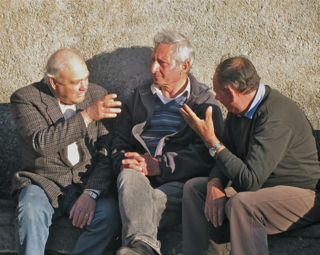 Drie Italiaanse mannen voeren een temperamentvolle discussie op straat.
