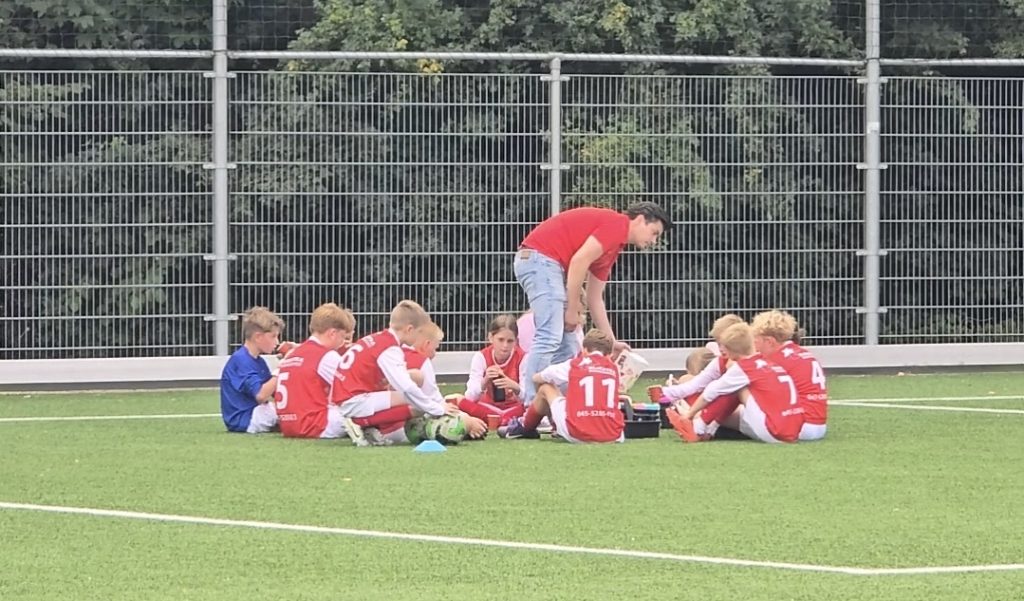 Het jeugdteam van VV De Leeuw zit bij elkaar tijdens een overleg met de trainer