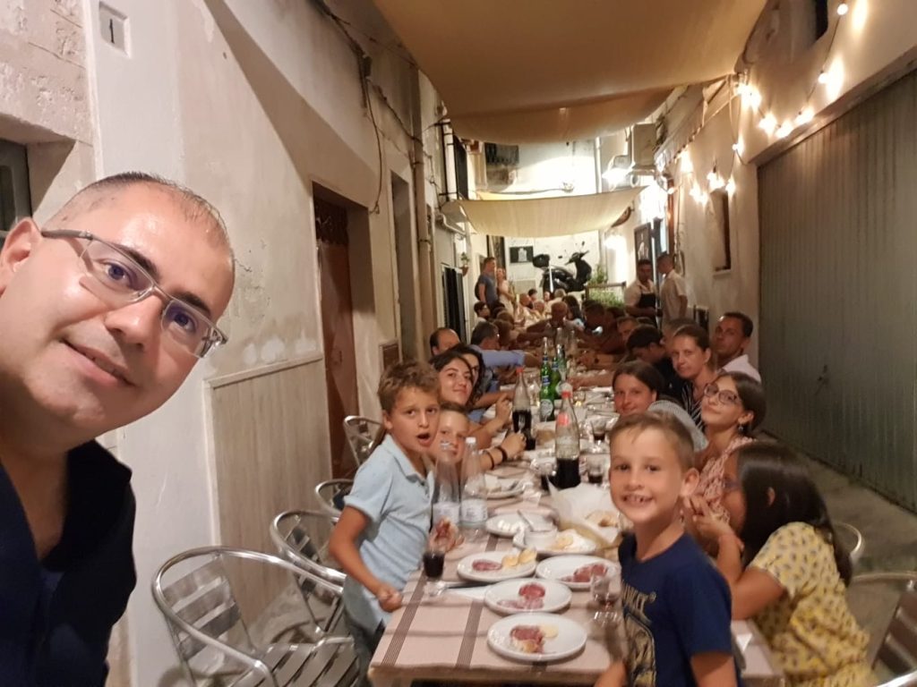 Familie aan tafel in de straten van Ostuni tijdens de zomervakantie.
