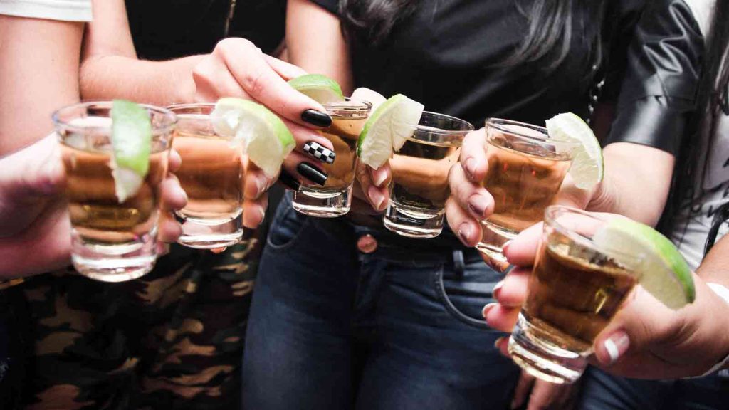 Vrienden drinken tequila shots tijdens zomervakantie