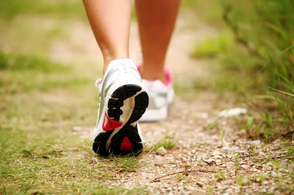 Wandelende vrouw in sportschoenen als onderdeel van afvallen slanker leven