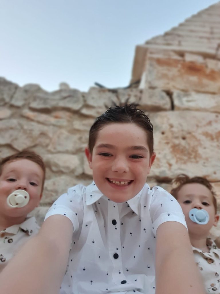 Drie broertjes lachen samen tijdens een selfie op vakantie