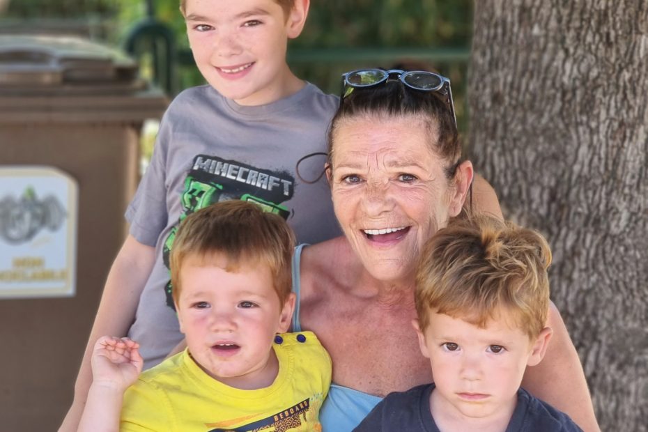 Oma poseert vrolijk met haar drie kleinkinderen tijdens de vakantie.
