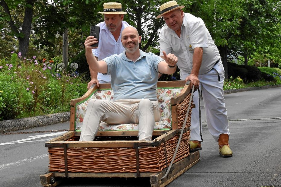 Selfie tijdens de traditionele toboggan-rit in Monte op Madeira, met bestuurders in wit uniform.