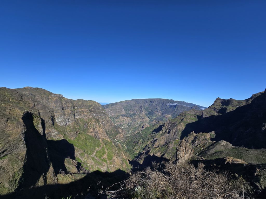 Donkere bergschaduwen boven een wolkendek in de vallei van de PR13-hike op Madeira.
