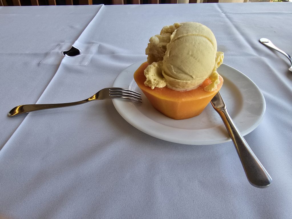Halve papaja gevuld met vanille-ijs als fris dessert na een warme dag hiken op Madeira.
