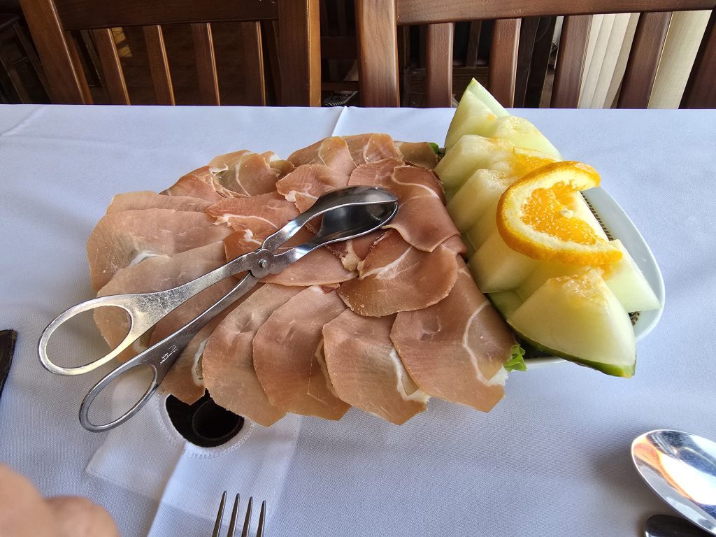 Bord met dun gesneden presunto-ham en verse meloen in een lokaal restaurant bij Ribeira Brava.