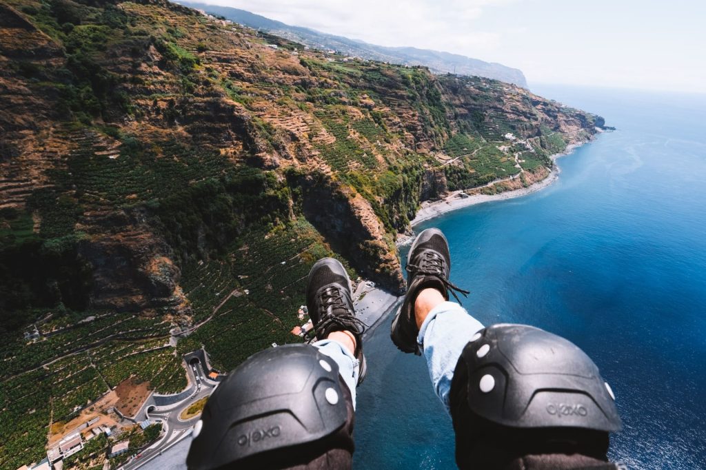 Paragliden boven kliffen en oceaan bij Madeira. Symbool vrijheid tijdens soloreis