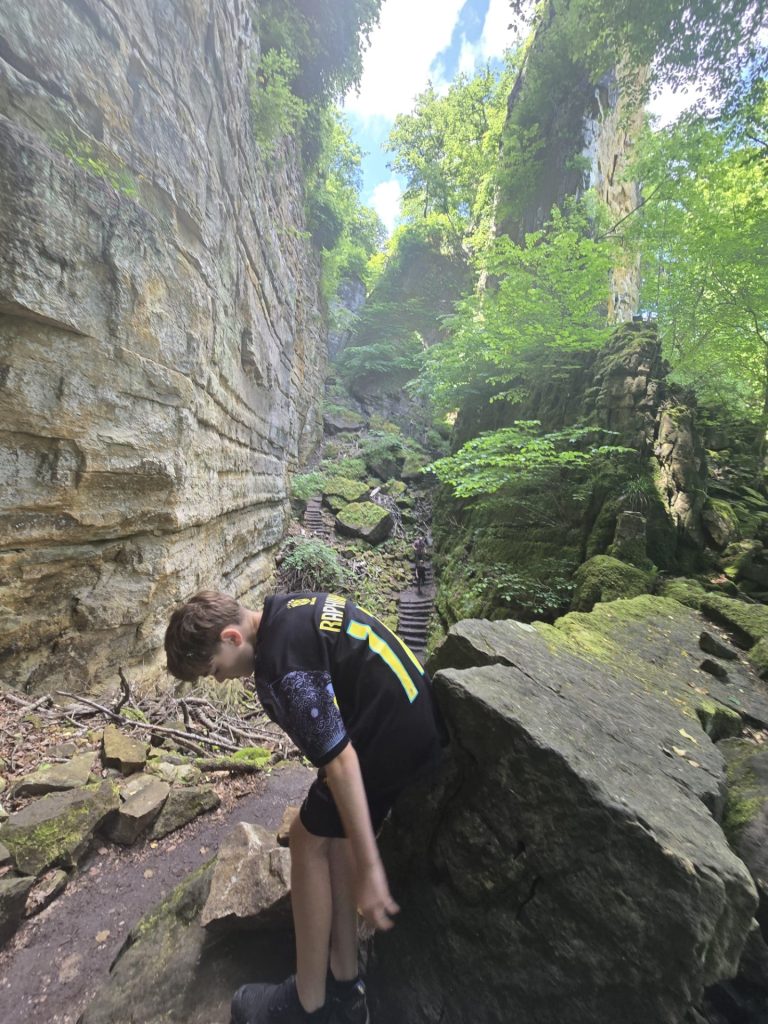 Steile rotswand en smal pad op de Mullerthal Trail E1, Luxemburg. Dit is de Wolfsschlucht.